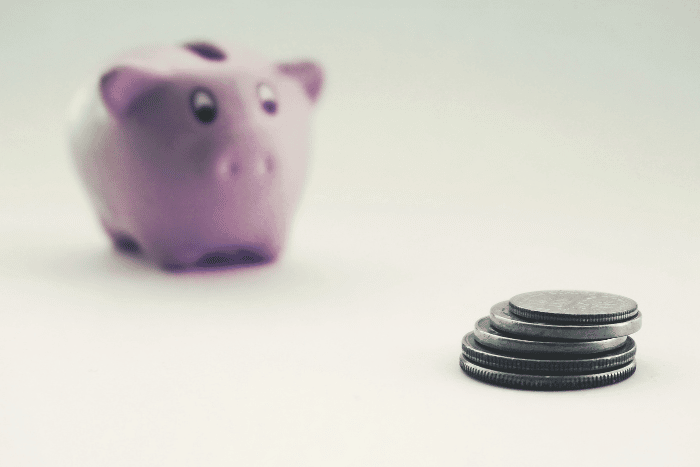 pink piggy bank with stack of coins
