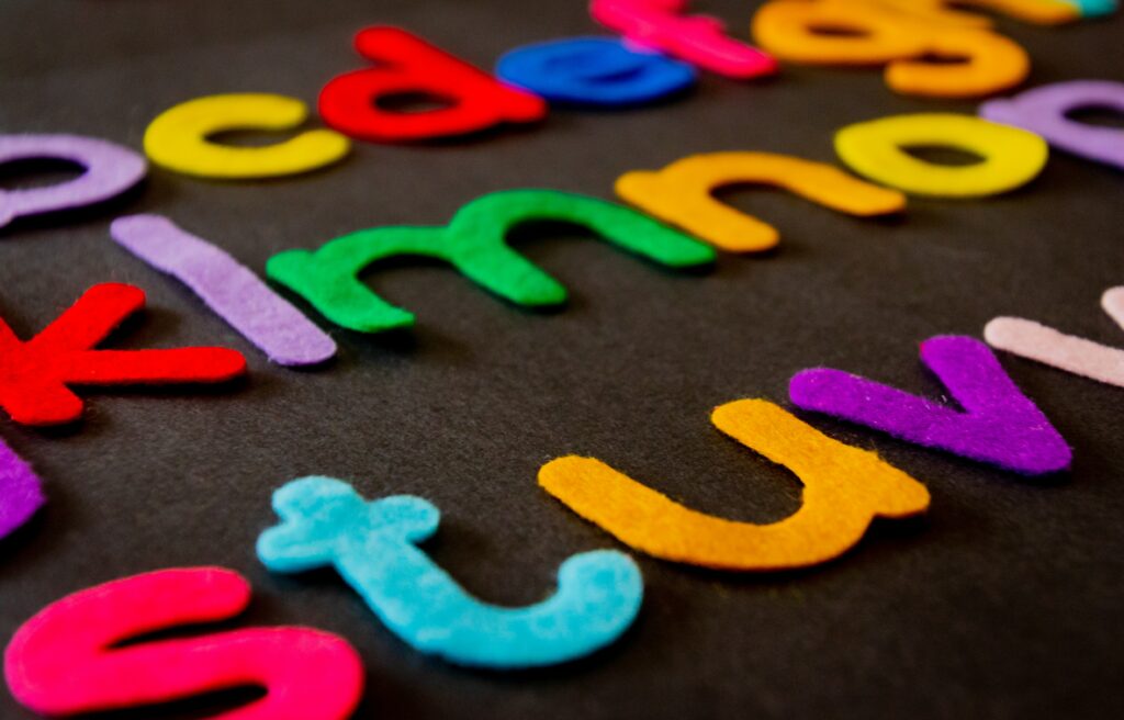 multi-colored felt alphabet on black background