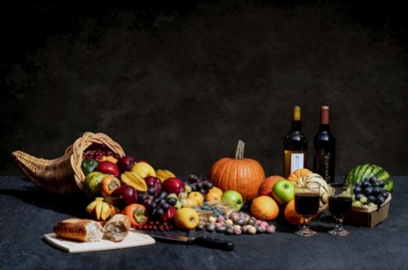 cornucopia of fruit, vegetables, bread, and wine