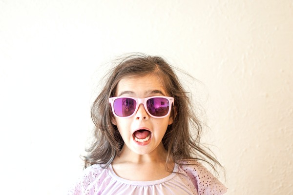 brown haired girl in pink sunglasses with suprised expression